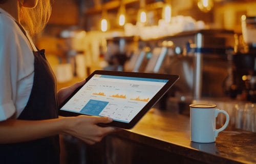 A business owner at a café in Albemarle County browses their AI-personalized website that displays location-based content for local users.